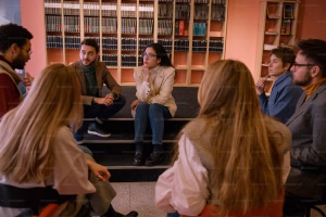 A group of people discussing books that look far more studious than we ever will